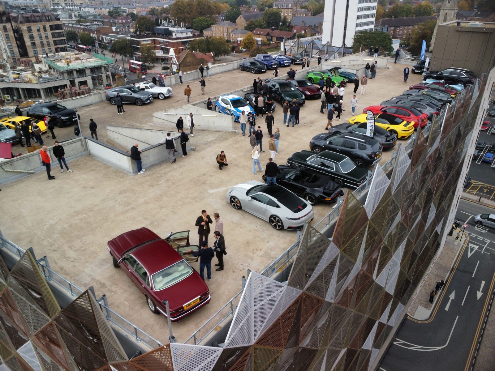 A rooftop gathering of private plate cars and attendees